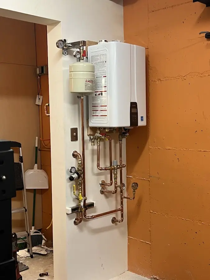 Plumbing technician inspecting water heater connections in Somerset